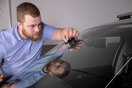 monteur bezig met reparatie aan voorruit