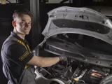 ServiceOnly monteur lachend bij motorkap