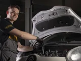 ServiceOnly monteur lachend bij motorkap