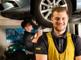 lachende ServiceOnly monteur met wekende ServiceOnly monteur op de achtergrond