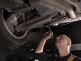 ServiceOnly monteur onder auto met zaklamp