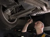 ServiceOnly monteur onder auto met zaklamp
