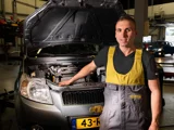 ServiceOnly monteur bij open motorkap