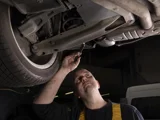 ServieOnly monteur onder auto met een zaklamp